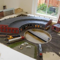 Overview shot, of the entire roundhouse, with the new background to the left. Newly acquired SP GP38-2 in lower right foreground. Also, turntable is now fully ballasted