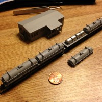 2 primed coil cars 70 foot carring four coils under each cover in z scale along with double wide frame house.