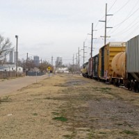 Sand Springs Ry. train headed to BNSF interchange. Note Tulsa,s downtown skyline in the distance