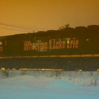 W&LE 3073 was seen idling on the end of the Wheeling and Lake Erie line in Connellsville, waiting to get onto CSX. It was joined up with W&LE 6316 and W&LE 3067. This engine is an ex-Union Pacific SD40-3 built in December 1966. The background lighting for this was created by the lights of the Connellsville Municipal Authority (a large sewage treatment plant). Normally the light does not appear so bright at night but the deep snowcover reflects all the light back into the air. "Night Landscape" setting with about -0.7 EV was used with this. Date as 01/06/2010.