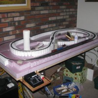 June 2, 2010 - Added a board for the power pack to sit on, and glued some of the track bed down.  It still looks pretty messy and needs lots of work.