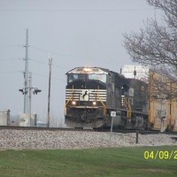 A SD70MAC is on the point in front of a dash 9 and a mixed frieght.
