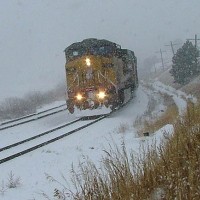 Emerging from a blinding blizzard, coal loads descend the 2% grade near Rol